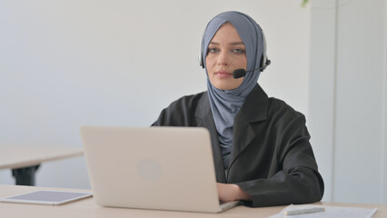 Arab Businesswoman with Headset Looking toward Camera in Call Centre