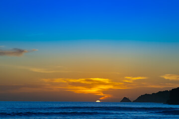 Sunset sunrise over Patong Beach Phuket Thailand clear blue and turquoise waters and lovely blue skies sun setting over the horizon of Andaman sea 