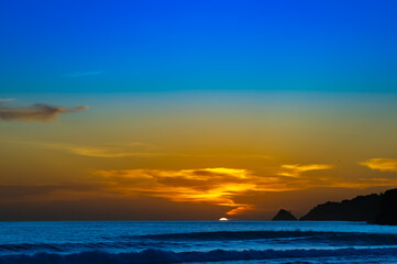 Sunset sunrise over Patong Beach Phuket Thailand clear blue and turquoise waters and lovely blue skies sun setting over the horizon of Andaman sea 