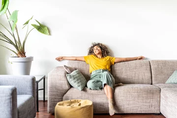 Papier Peint photo Lavable Échelle de hauteur Happy afro american woman relaxing on the sofa at home - Smiling girl enjoying day off lying on the couch - Healthy life style, good vibes people and new home concept