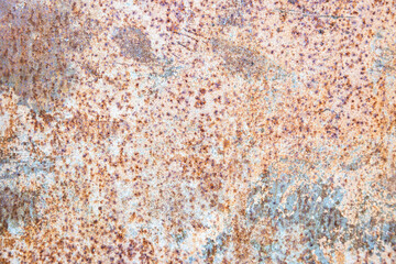 Old rusty metal texture on the surface of an iron sheet with pitting, grunge background.