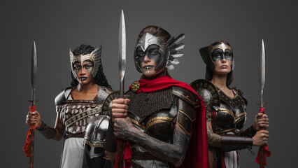 Shot of three warriors women dressed in steel armors with spears.
