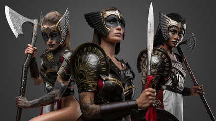 Portrait of three attractive female warriors dressed in iron armors.