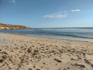 The sandy shore of the ocean is resting from tourists