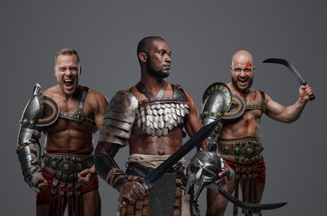 Naklejka premium Shot of multiethnic antique gladiators dressed in armour posing together.