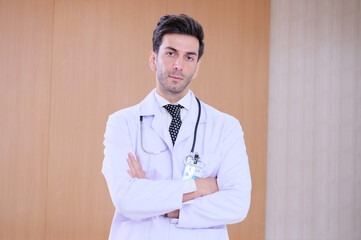 Smiling male doctor standing in hospital.