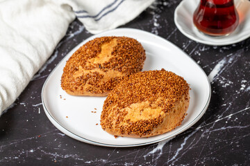 Sesame and cheese pastry on dark background. Turkish street food. Peynirli pogaca