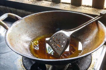 Used vegetable oil or old cooking oil in a pan on a gas stove.