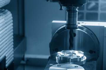 The CNC milling machine hole cutting the automotive parts by drill tools.