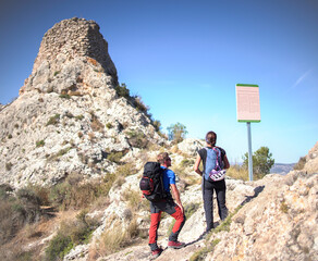 Sportsmen and women climb mountain through via ferrata in Villena, Spain.