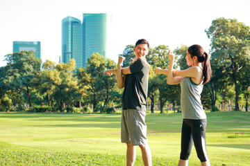 Asian couple exercising together in the park in the morning They are strong and healthy. outdoor...