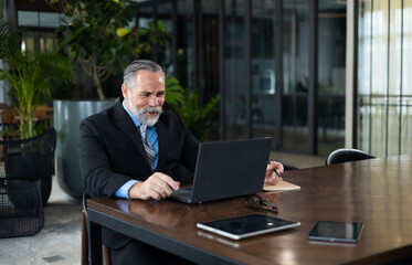 portrait of caucasian CEO business leader senior manager woking on laptop computer at office coworking space