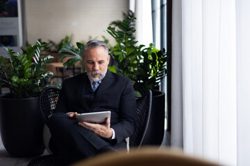 portrait of caucasian CEO business leader senior manager standing by window thinking