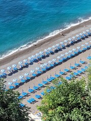 Fototapeta premium Blue umbrellas lined up on the beach