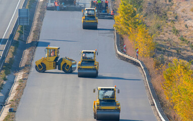 Road rollers leveling fresh asphalt pavement