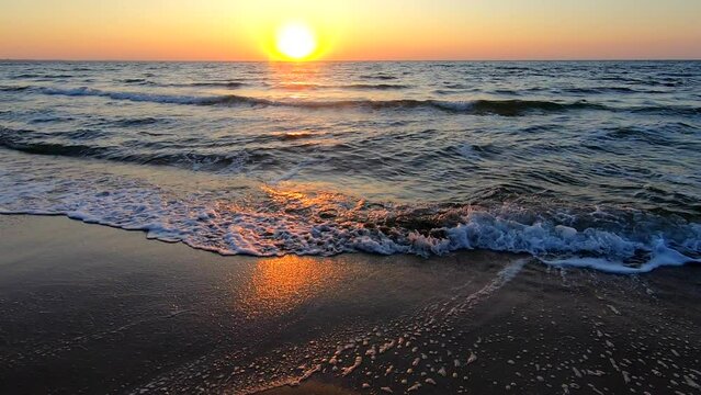 Sunrise, sunset on the sea. Rising sun, setting sun over rolling sea waves with white foam. Sundown dawning on sea. Sea water sun sky morning. Seascape view. Natural nature background. Slow motion.