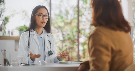 Portrait of an Asian Healthcare Professional Listening to a Senior Female Patient Before Prescribing Treatment for Her Medical Condition During a Consultation in a Modern Health Clinic
