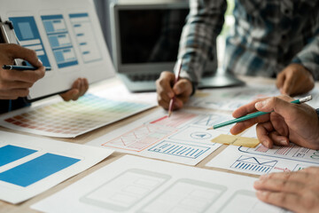 Group of asian creative team programing designers participate in all phases of the UX design.