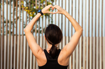 Fototapeta premium Young caucasian slim lady in sportswear shows heart gesture with hands, enjoy workout and fitness