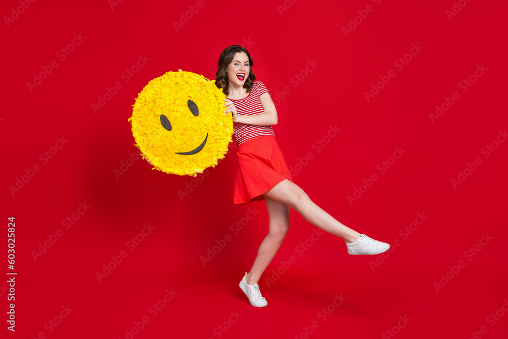 Wall mural Full size photo of carefree positive girl dancing arms hold large smiley emoji collage isolated on red color background