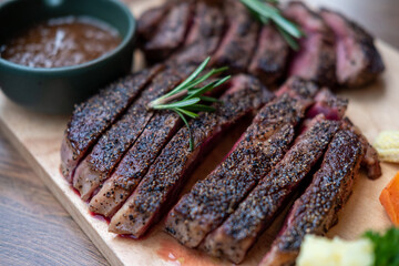 Medium rare meat on wooden plate