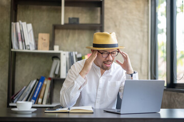 Asian businessman working hard Feeling stressed out and dizzy from job on laptop. reading bad news in email, lost information, app malfunction