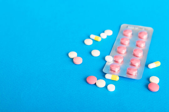 Blister package with Vitamin on color background. Medicine pills on a light background. Medicines and prescription pills flat lay background. pink medical tablets in blister