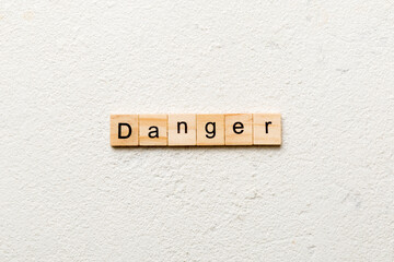 Danger word written on wood block. Danger text on cement table for your desing, Top view concept