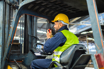 Forklift driver talking on radio for professional cargo shipping communication
