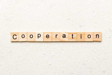 cooperation word written on wood block. cooperation text on table, concept