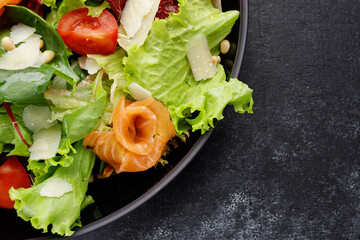 fresh salmon salad with Parmesan cheese, tomatoes, and mixed greens