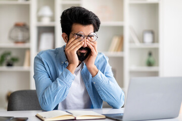 Indian Man Suffering Eyes Strain While Working With Laptop At Home Office