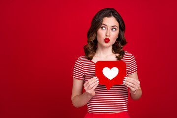 Photo of cute blogger lady send air kiss red lipstick hold paper heart popularity instagram post wear top isolated red color background