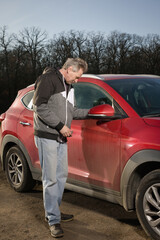 Older man take care annd cleaning car outdoor on nature parking