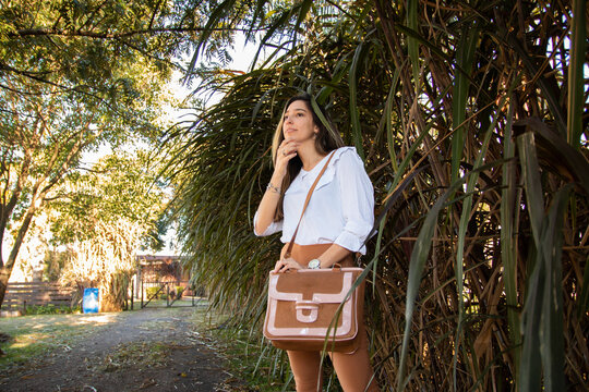 Mujer joven y hermosa usando cartera de cuero