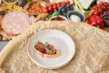 The waiter makes bruschetta or tapas. Table full of mediterranean appetizers, tapas or antipasto. Assorted Italian food set. Delicious snack on party or picnic time. Italian style banquet. 