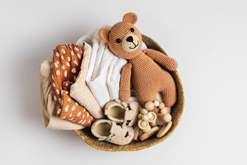 Basket with baby stuff and accessories for newborn. Gift basket with cotton clothes and muslin...
