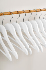 Wooden white hangers in wardrobe. Clothing rack for children's outfits. Clothing Rack.