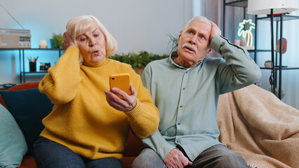 Senior family grandparents man woman use smartphone typing browsing, loses surprised by lottery...