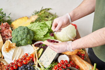 The waiter makes bruschetta or tapas. Table full of mediterranean appetizers, tapas or antipasto. Assorted Italian food set. Delicious snack on party or picnic time. Italian style banquet. 