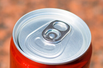 Red tin can with drink on brown background