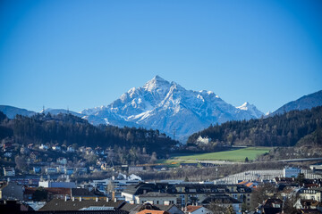 Alps Mountain. A beautiful landscape of Alps mountain with bright blue sky, vignette applied. City and villages are surrounded on the foreground.