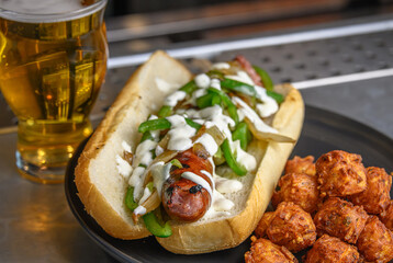Grilled Bratwurst Sandwich with Tater Tots and a Draft Beer