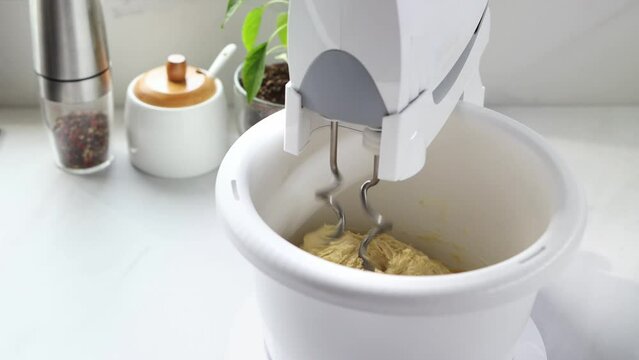 Mixer stirs the dough in a spinning bowl. A stationary mixer with a bowl kneads the dough. High quality 4k footage.