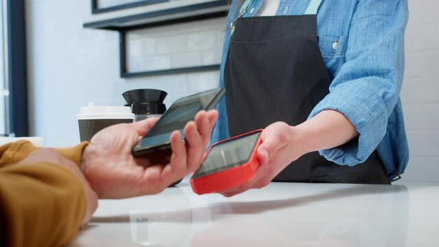 Close-up: a customer makes a purchase in a coffee shop, pays with a QR code. Scans the QR code with a smartphone in the bank's application. New technologies in digital finance. Electronic payment