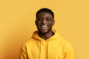 Fototapeta premium Handsome black guy in casual posing on yellow, copy space