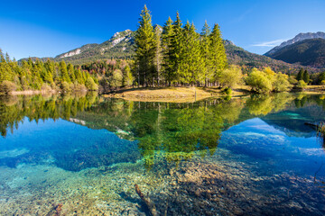Fototapeta na wymiar panoramic landscape at springtime with beautiful lake and alps mountain range in backround