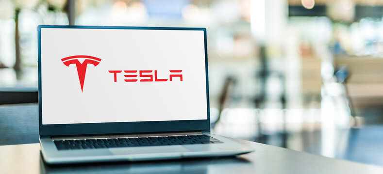 Laptop computer displaying logo of Tesla