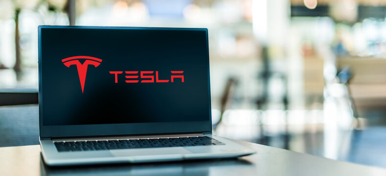 Laptop computer displaying logo of Tesla