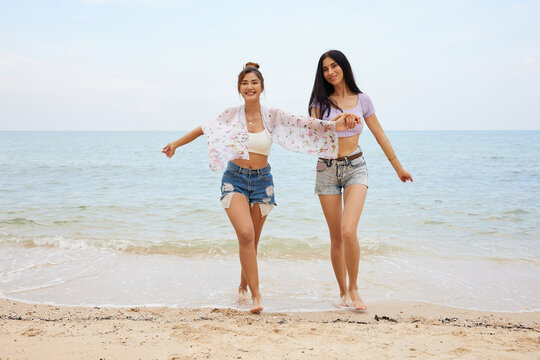 young women or lesbian couple holding hands together and enjoy travel on the beach